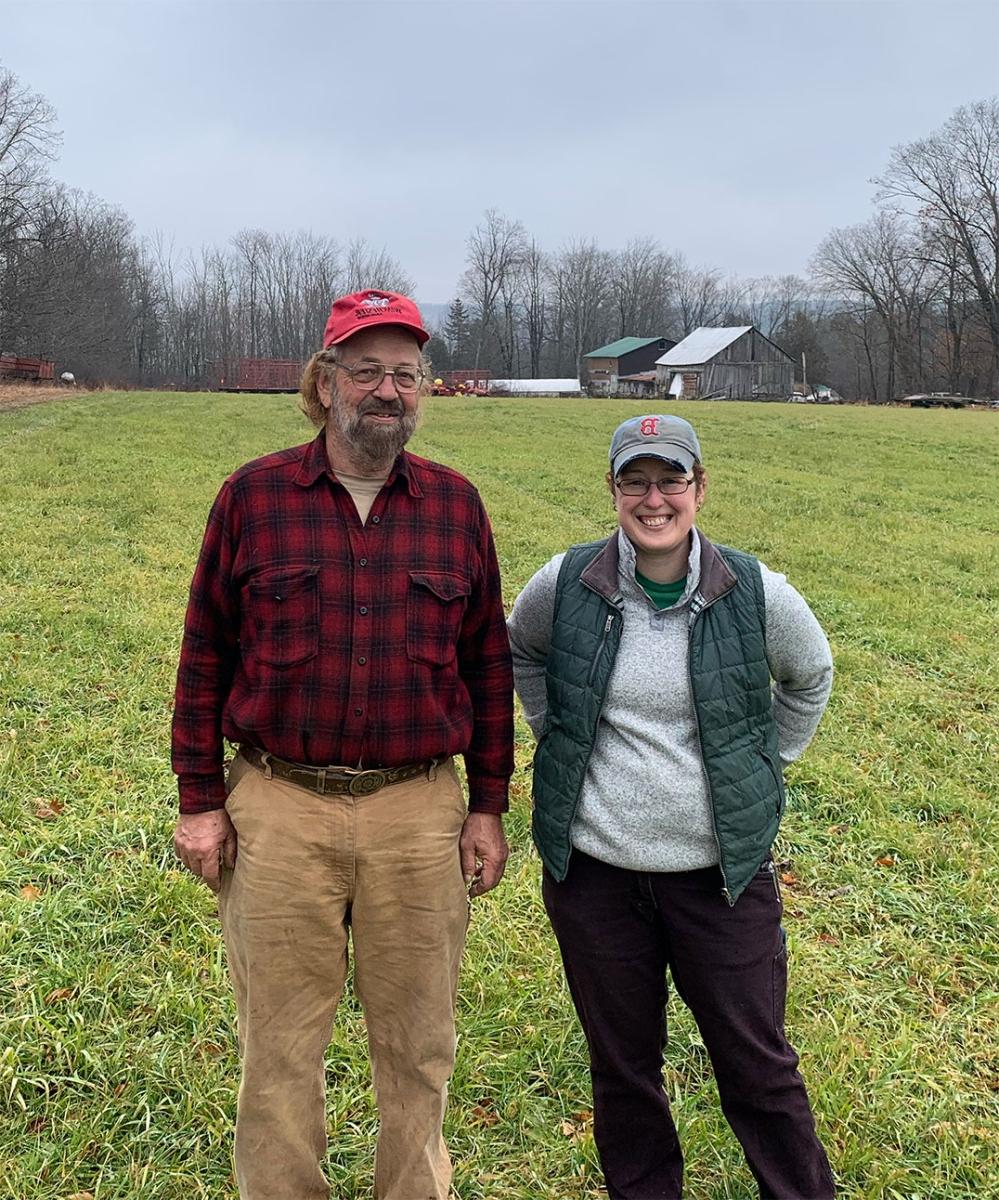 一个白人妇女和一个年长的白人男子站在农田里的照片.